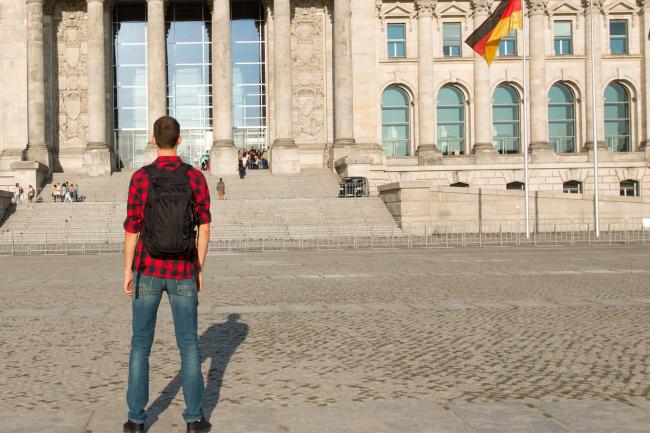 Недовольный иммигрант смотрит на здание Рейхстага